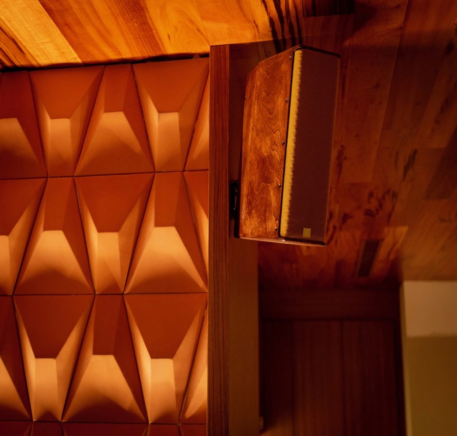 Close view of a warm-toned loudspeaker and a faceted interior finish.